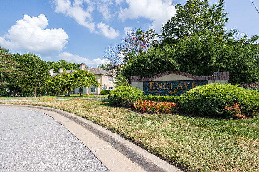 A welcoming entrance to Enclave at Town Center, featuring beautifully maintained signage and landscaping. - Enclave At Town Center