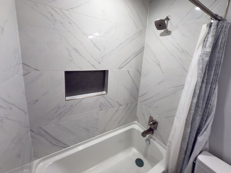 Shower detail with marble tile, showerhead, and recessed niche - 2006 Candle Ct