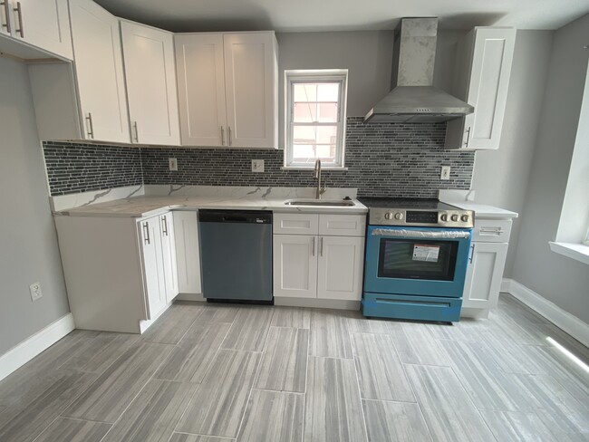 Large sunny modern white kitchen, quartz countertop, porcelain tile floor, stainless steel appliance - 1618 Fitzwater St