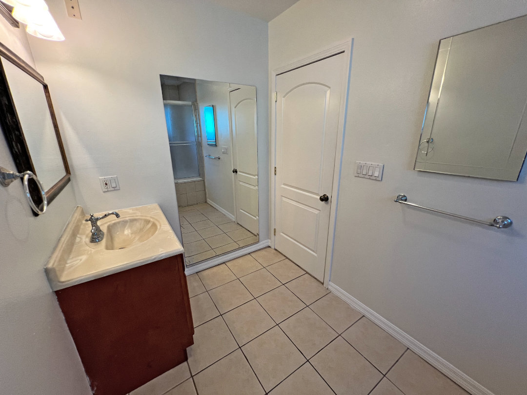 Primary bathroom with large mirror. - 2330 S Mansfield Ave
