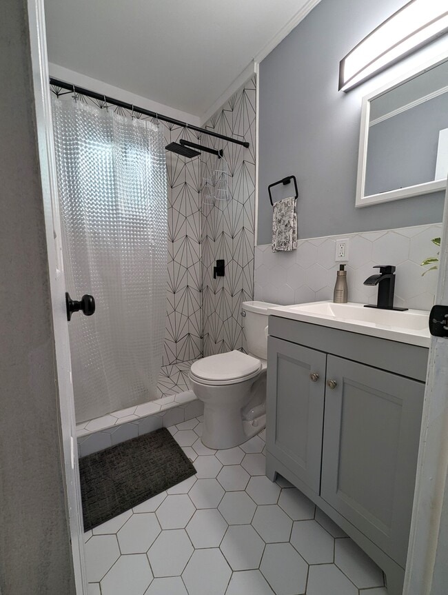 The bathroom is completely updated with custom tile work a rain shower and modern fixtures. - 4107 Crane St