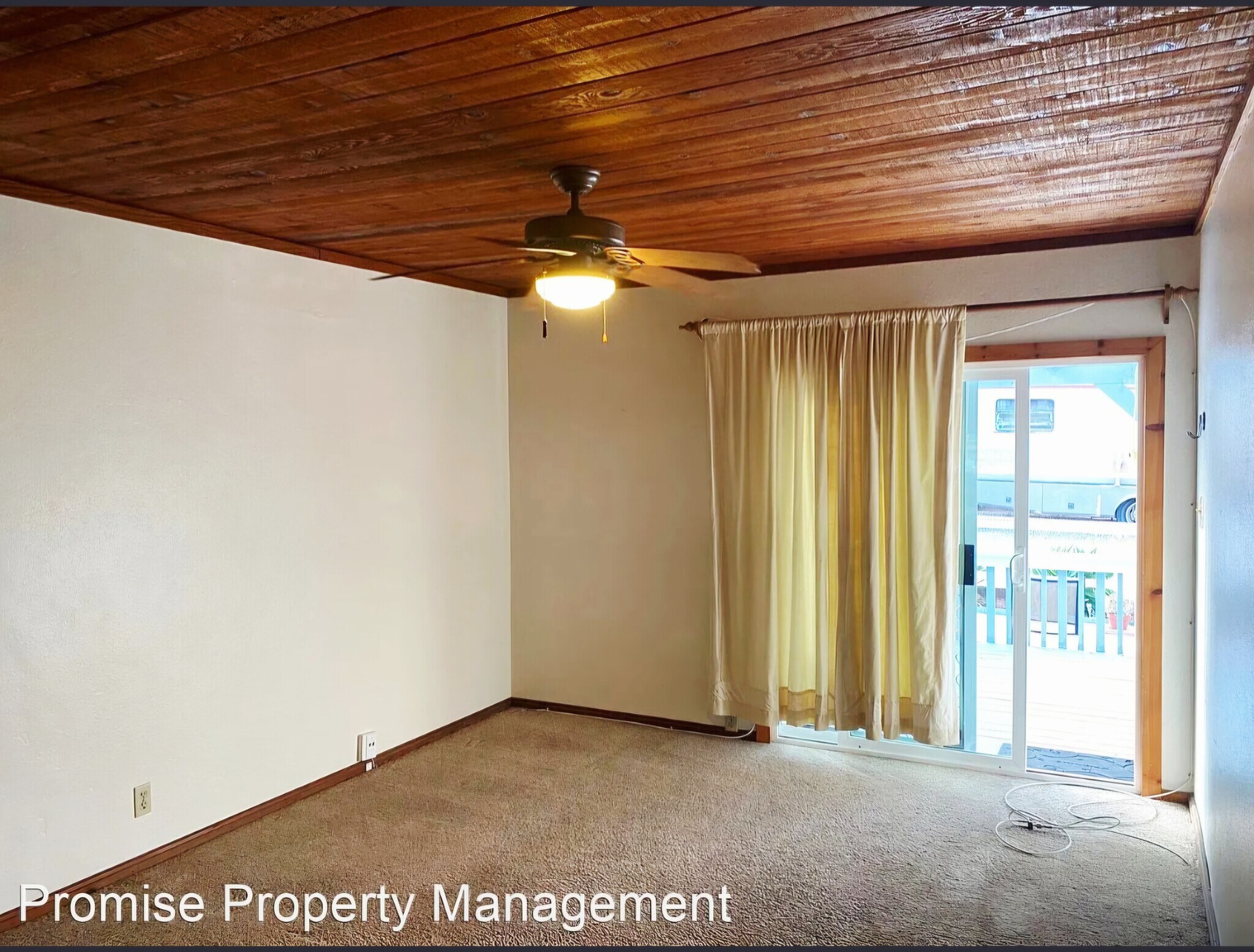Carpeted living room w/ceiling fan & slider entrance. - 934 S Myers St