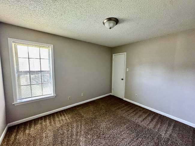 Building Photo - Charming 3BR/2BA Near Southwind | Soaring Vaulted Ceilings, Brick Fireplace & Fenced Yard