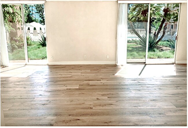 Living room showing both sliding doors - 100 S Doheny Dr