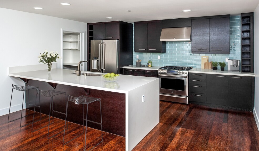 Designer kitchens with quartz countertops, stainless steel appliances and a breakfast bar - Preserve at Marin