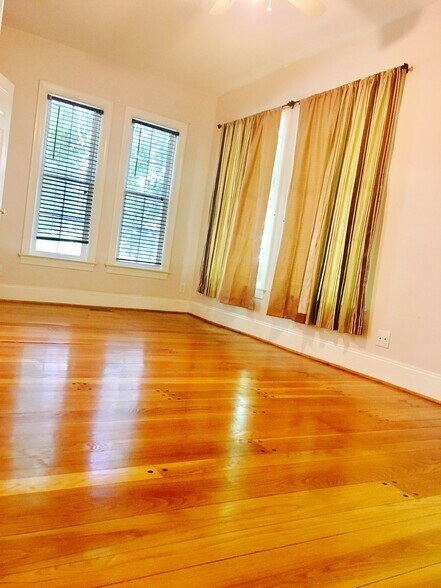 Bedroom with hardwood floors, high ceilings, and calm, sunlit comfort. - 1937 Fairfield Dr