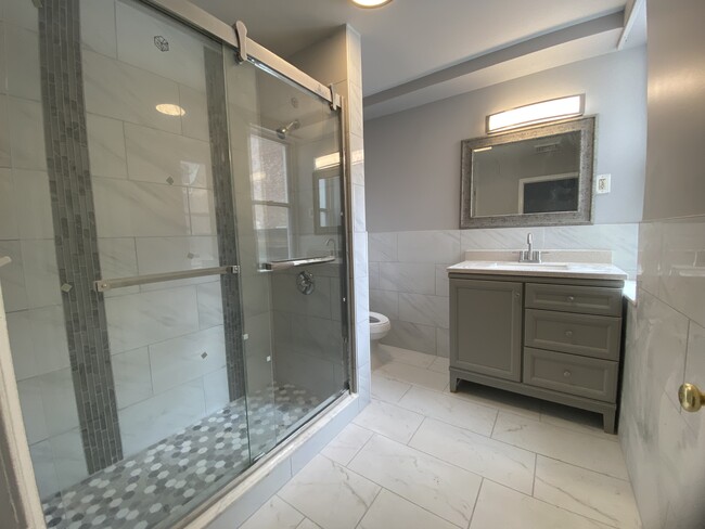 Modern spacious full bath, large shower, porcelain tile floor, granite countertop - 1618 Fitzwater St