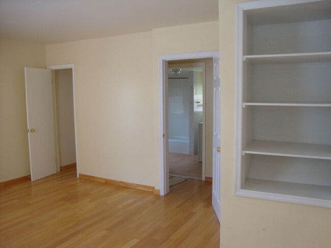 Bedroom with closet on left, handy shelving on right, and door looking toward the bathroom. - 239 W Venango St