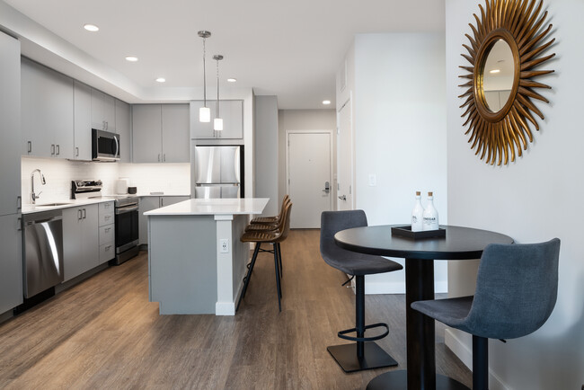 Kitchen, living, and dining areas with hard surface flooring throughout - Avalon Brighton