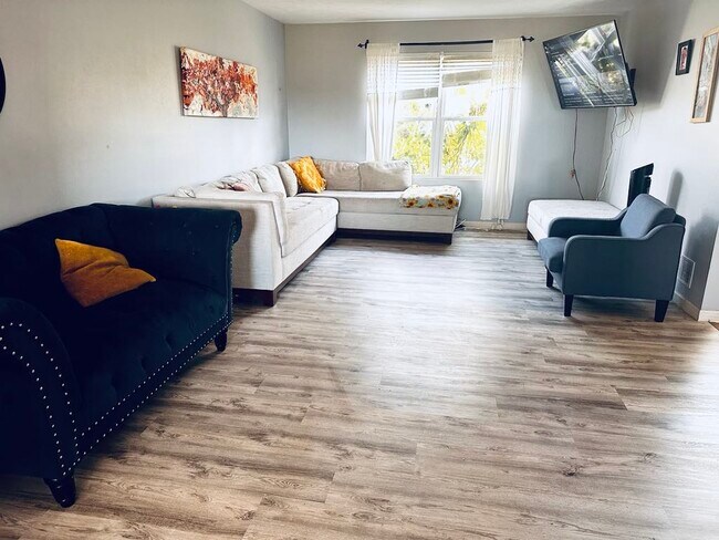 A spacious living room with newly installed flooring - 4555 Cider Wood Dr NW