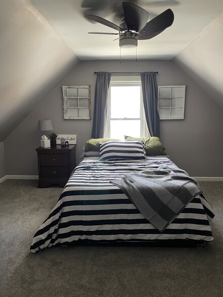 Bedroom upstairs, no closet, but hanging racks on walls. - 438 E 7th St