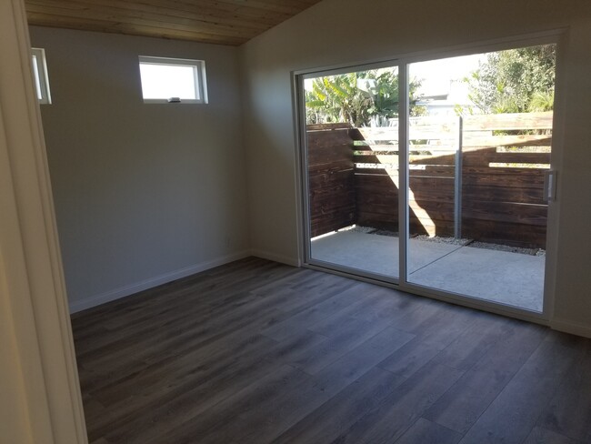 Master bedroom with wood high ceilings, ceiling fan, private courtyard, custom driftwood mantel over - 6832 Zelzah Ave