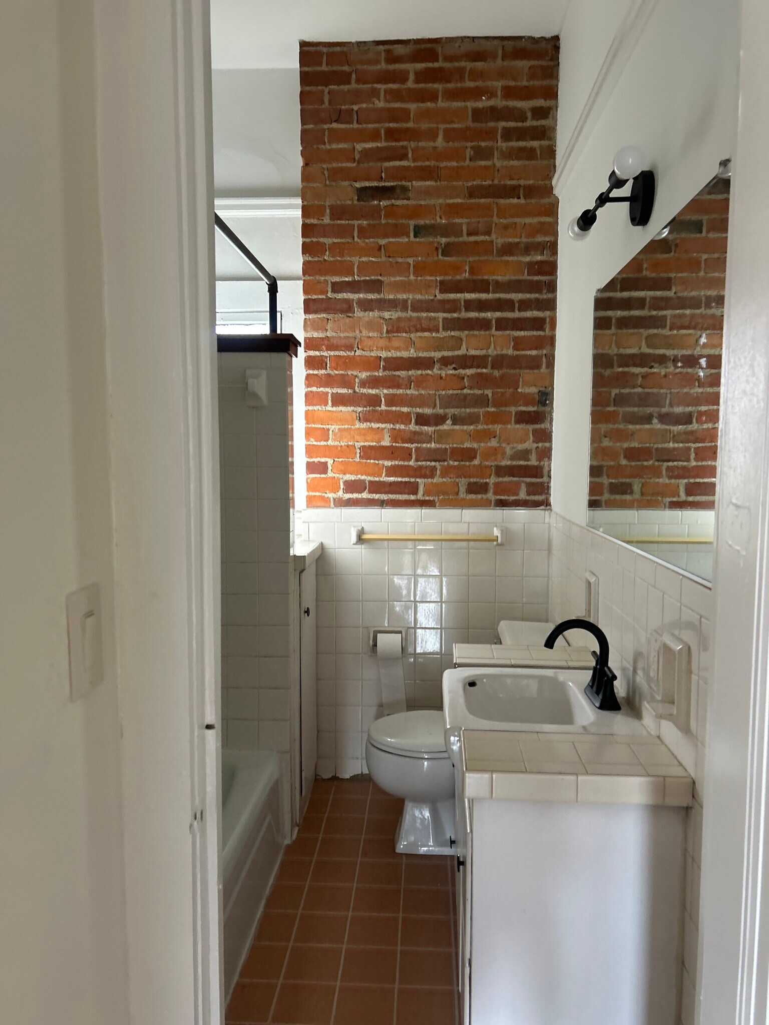 Full bath with window and exposed brick - 611 S 3rd St