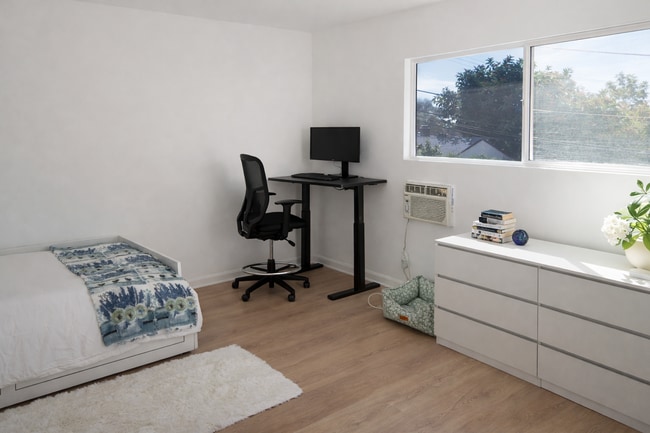 Third Bedroom with Home Office Setup: Electric Standing Desk, Office Chair, and Computer Screen - 5860 Hazeltine Ave