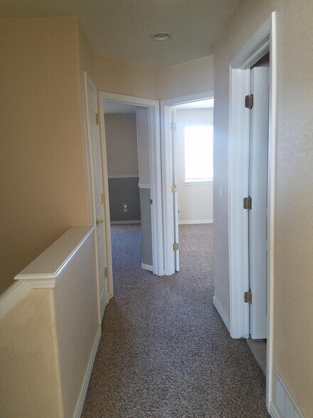 upstairs hallway with full bath on right and 2 bedrooms at end - 695 S Depew St