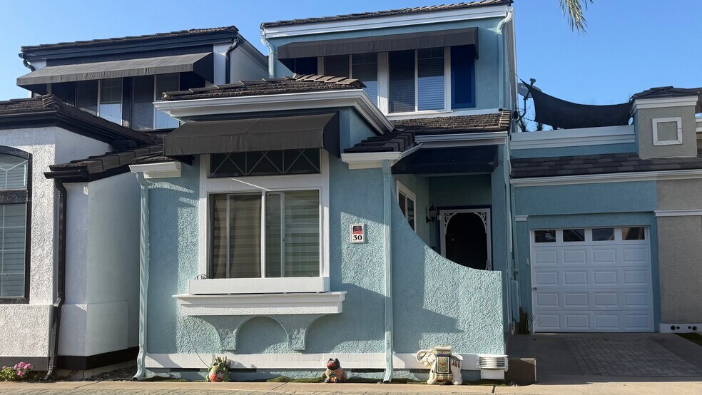 Newly painted front of house with covered patio - 700 Lido Park Dr