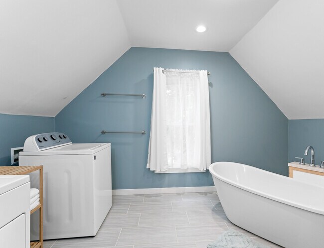 Large bathroom upstairs with tub, vanity, washer, and dryer - 1110 W Grand Ave
