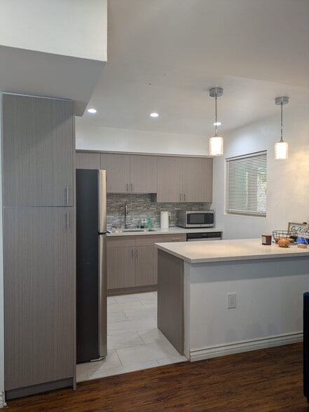 Modern kitchen with Euro cabinets, quartz countertops, and new stainless steel appliances - 5652 Yolanda Ave