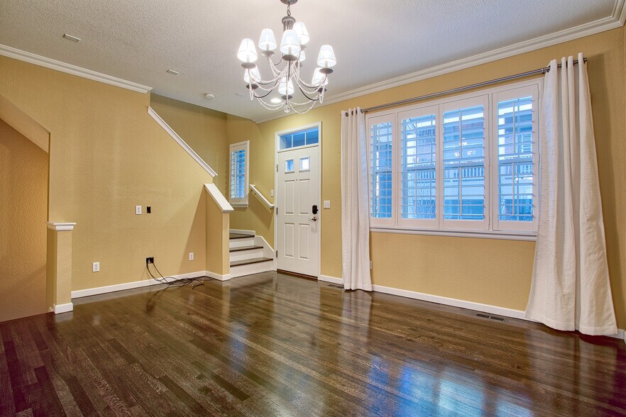 Living room with hardwood floors, plantation shutters, crown moulding, chandelier - 7422 E 7th Ave Unit 14