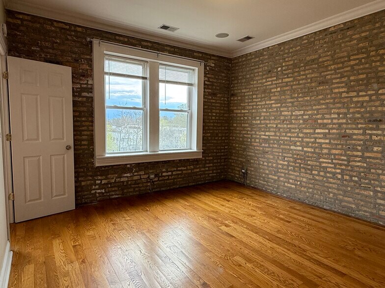 Primary Bedroom with exposed Brick - 6150 N Ravenswood Ave
