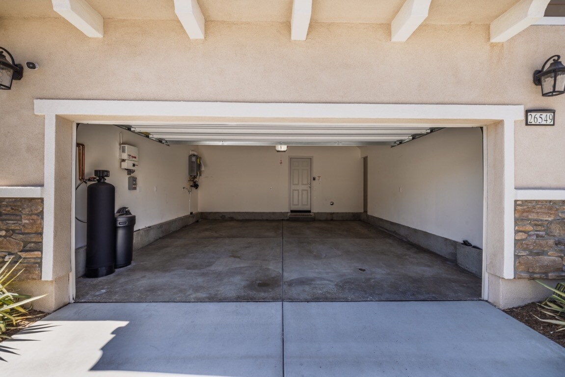 Spacious two-car garage with ample storage and a whole-house water filtration system - 26549 Brightstone Dr
