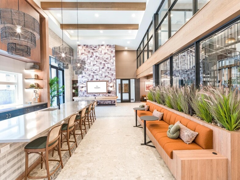 A vibrant social hub with space to gather, plug in, or unwind—designed for connection, comfort, and a little creative spark. - Modera Higley Commons