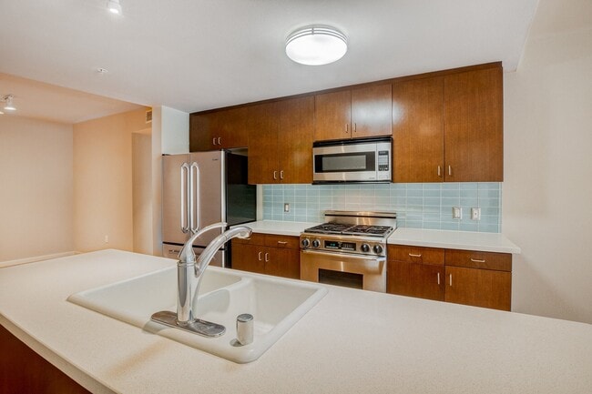 Kitchens are complete with Caesarstone countertops and decorative backsplash - 5550 Wilshire at Miracle Mile by Windsor