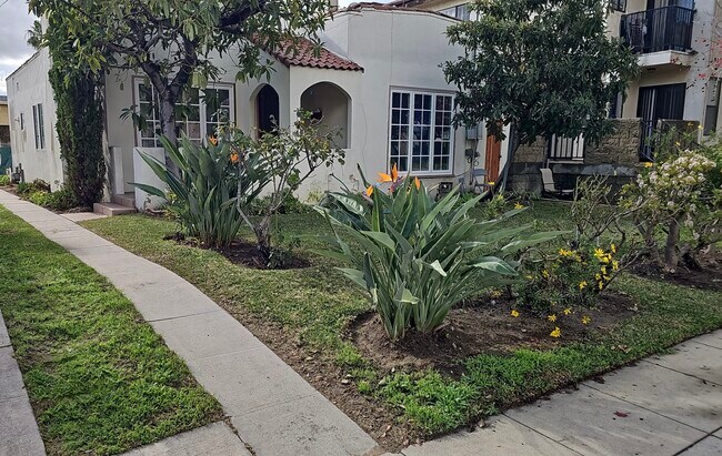 Exterior with front yard, flowers and trees. Gardening included in price. Exterior paint this month. - 918 E Elk Ave