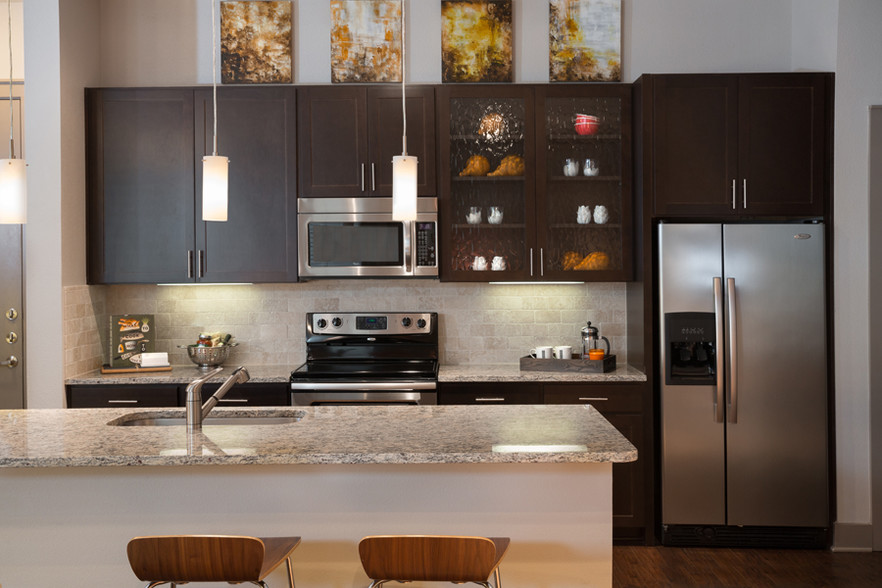 Gourmet kitchens feature granite or quartz countertops with natural stone backsplash - ICON at Ross