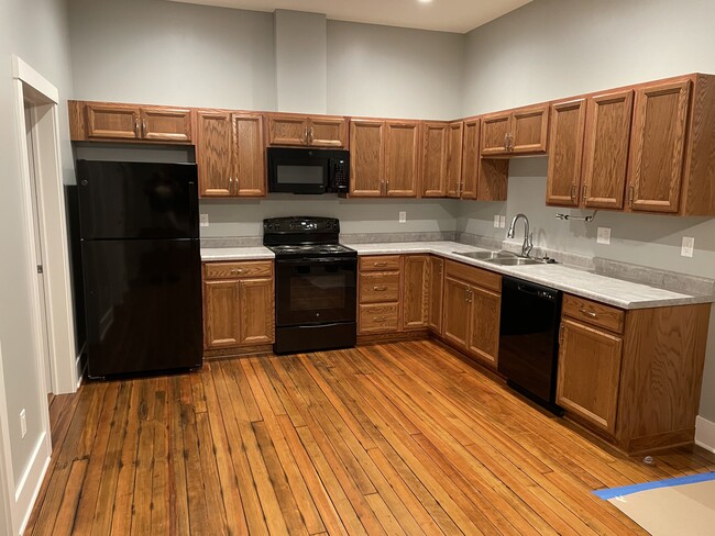 New kitchen cabinets, appliances and original refinished floors. Main room looking south. - 204 E Broadway Ave