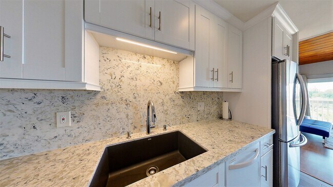 Beautiful updated kitchen with quartz countertop and white shaker cabinets - 6542 Ocean Crest Dr