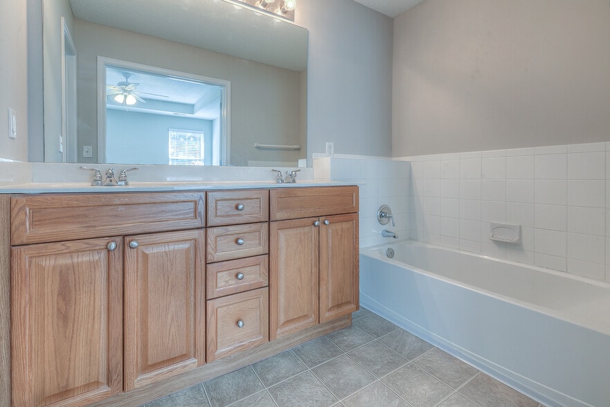 master bath with double vanity and tub - 22810 West 71st Terrace
