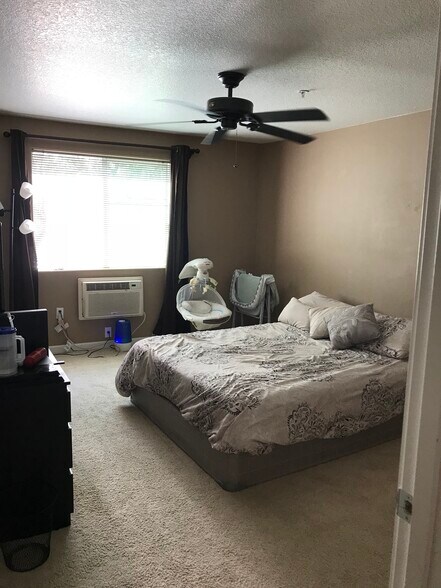 Large primary bedroom with ceiling fan and air conditioner - 730 NW 185th Ave