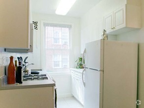 Kitchen with white cabinetry and appliances - eaves Tunlaw Gardens