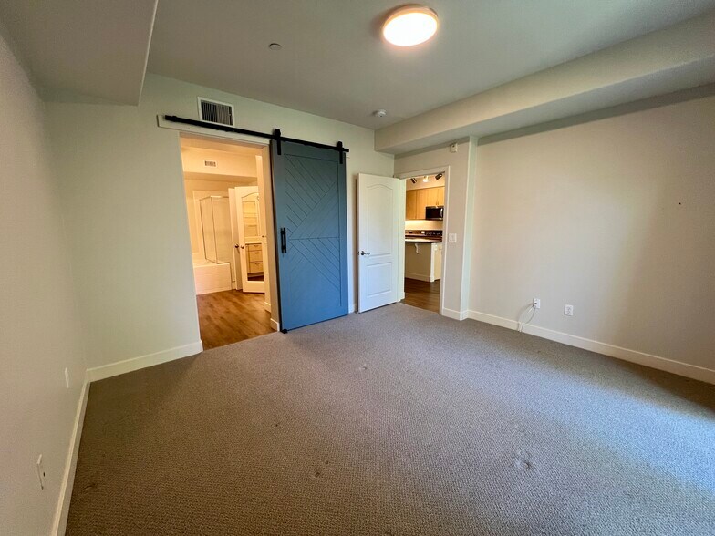 Primary bedroom with custom barn door to the bathroom - 8355 Station Village Ln