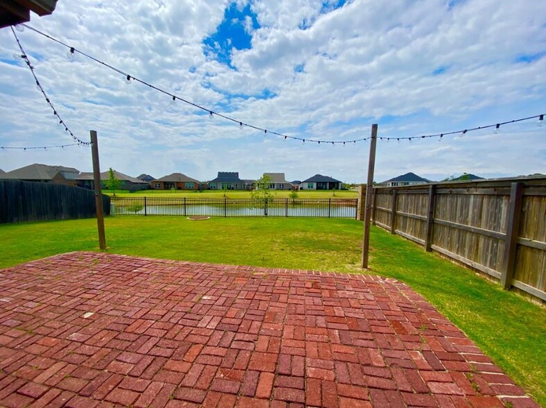 Backyard with extended pavers, outdoor lights, and pond view - 2452 NW 190th St