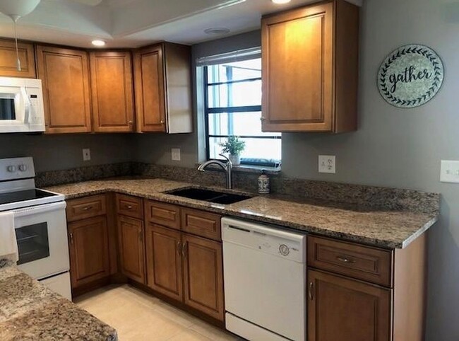 Granite countertops and wood cabinets in the kitchen. The cabinets have recently been painted white - 2321 SE 5th Ct