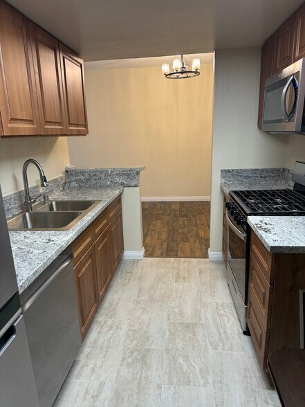 Kichen with SS appliances, marble counters and porcelain tiles. - 10824 Palms Blvd