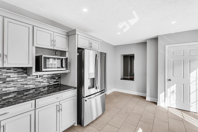 Solid granite countertops compliment the SS appliances. - 2416 Magee Road Ext