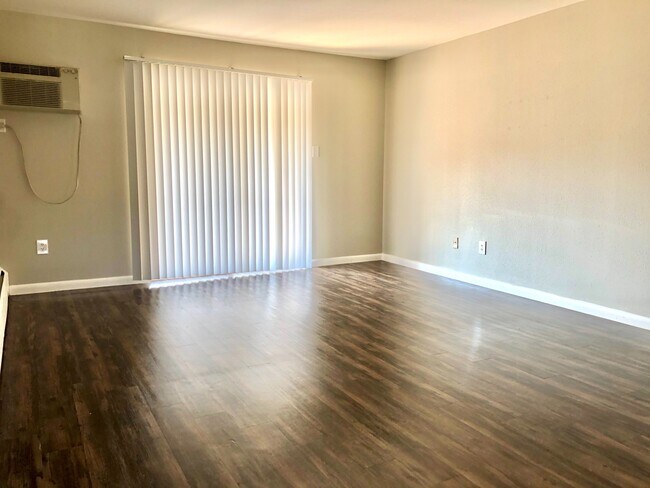 Experience open living in this bright space with stylish hardwood floors. - GRACE LANDINGS APARTMENTS