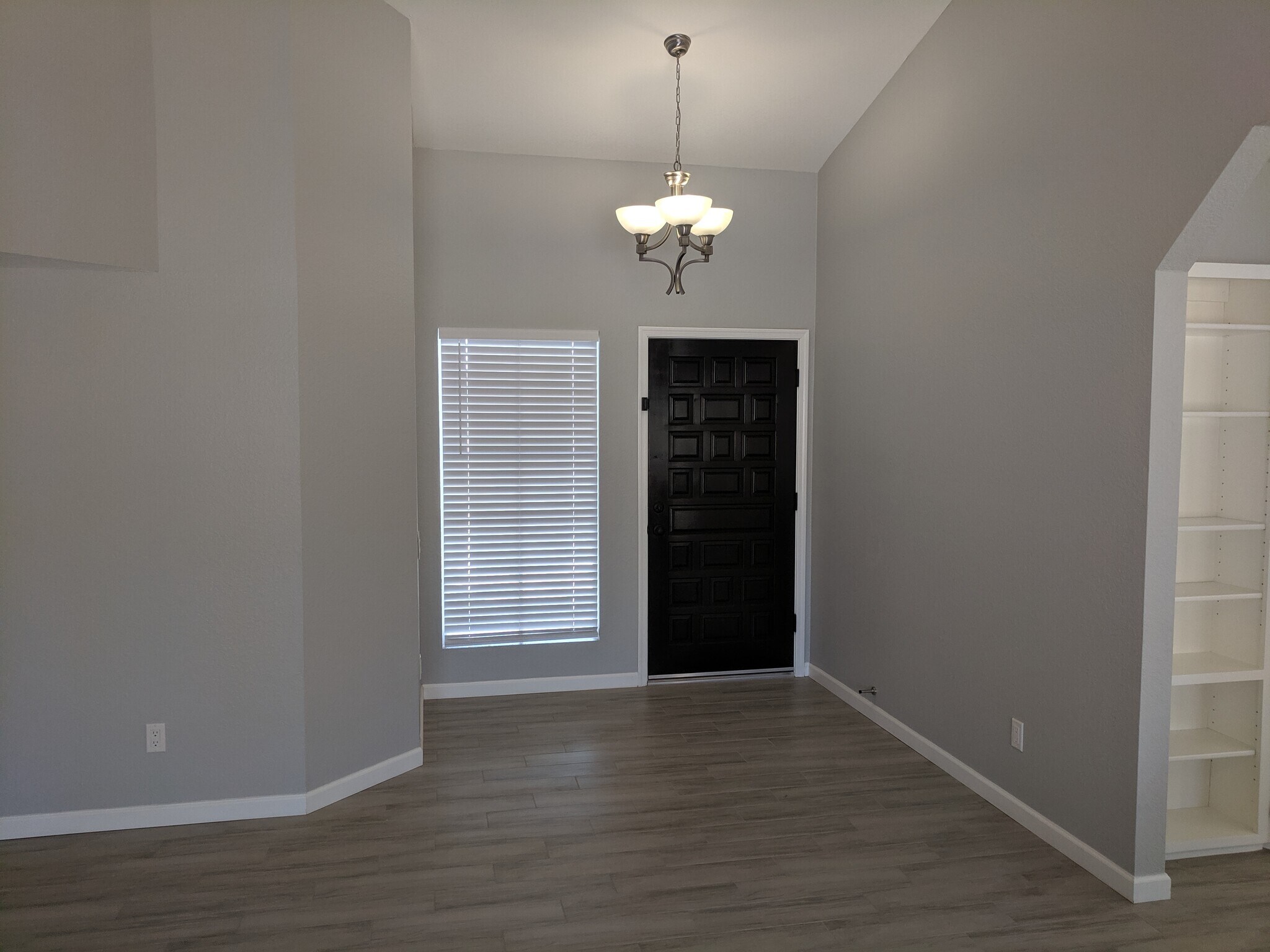 Front Door entry area with 3 light pendant brushed nickel light fixture. West wall. - 14101 N 78th Dr