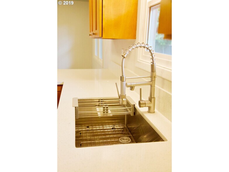 Updated kitchen with Quartz countertop and new sink and faucet. - 15421 SE Stark Street