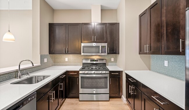 Kitchens feature stainless steel appliances and quartz countertops - Axiom Apartments