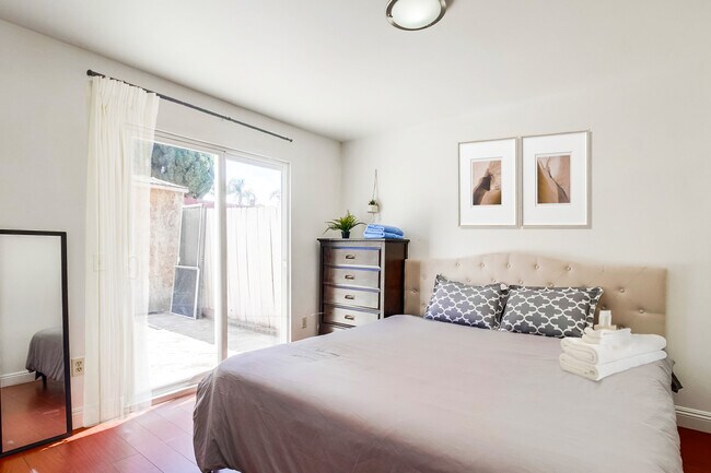 The master has a cozy king bed. Plus, a glass sliding door leading to the outdoor backyard. - 2304 E 14th St