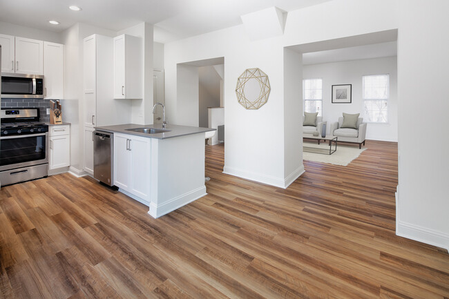 Kitchen, living, and dining areas with hard surface flooring - Avalon at the Hingham Shipyard