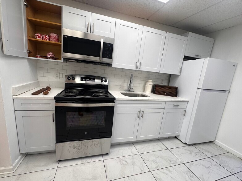 Fresh white kitchen with a brand-new stove and modern appliances. - 353 High St