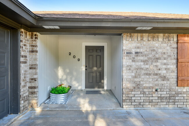 View of the freshly painted entrance to property. Room for small seating area or planters. - 209 Prairie Wind Blvd