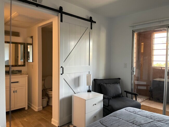 Bedroom with barn door to vanity and bath areas - 1810 E Blacklidge Dr