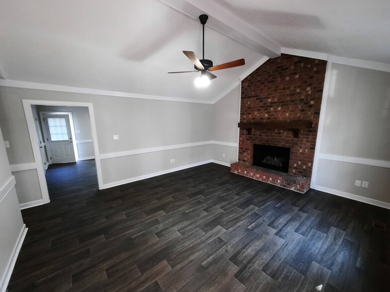 Spacious living room with vaulted ceiling and brick fireplace - 1717 Old Barn Rd