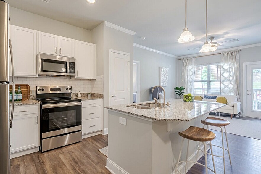 Experience the elegance of this modern kitchen, seamlessly connecting to a bright, airy living space. - Sanctuary at Powell Place